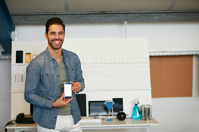 Buy stock photo Portrait of a young man displaying the screen of a mobile phone in a modern office