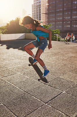 Buy stock photo Shot of a young woman skating in the city