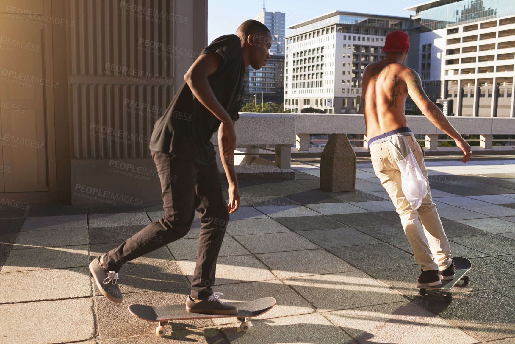 Buy stock photo Shot of two young men skating in the city