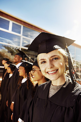Buy stock photo Portrait of a smiling university student on graduation day with classmates in the background
