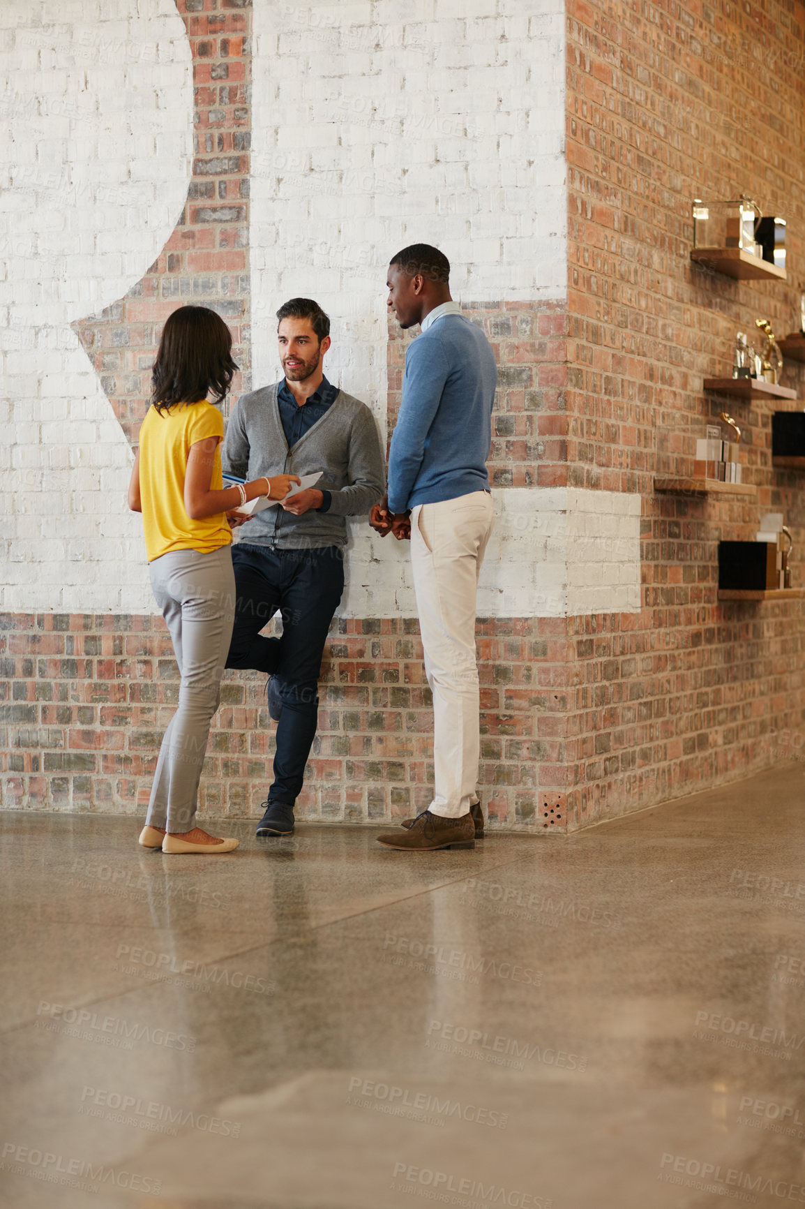 Buy stock photo Full length shot of three businesspeople talking while standing around in the office