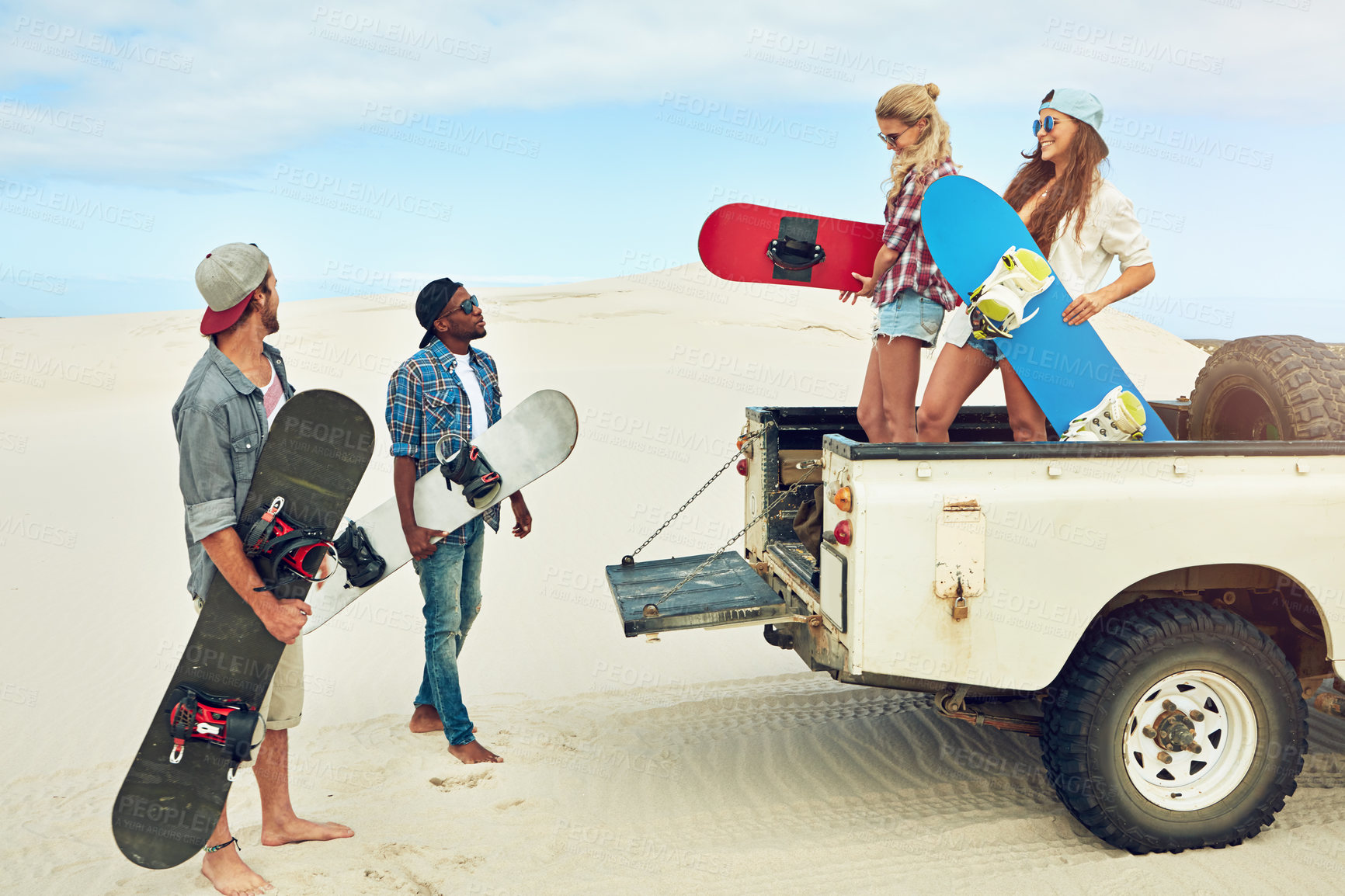 Buy stock photo Shot of a group of young friends going on a sand boarding road trip in the desert