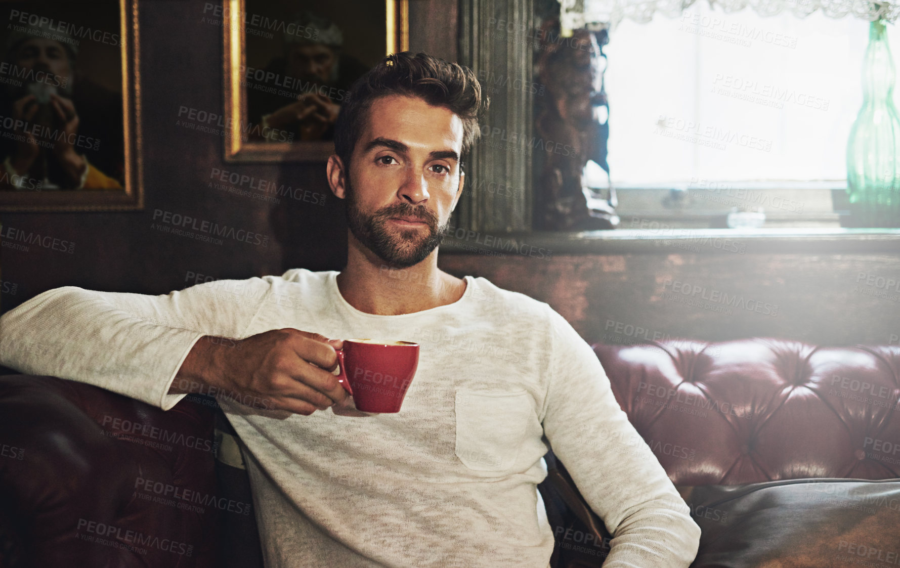 Buy stock photo Portrait of a handsome man having a cup of coffee at a cafe