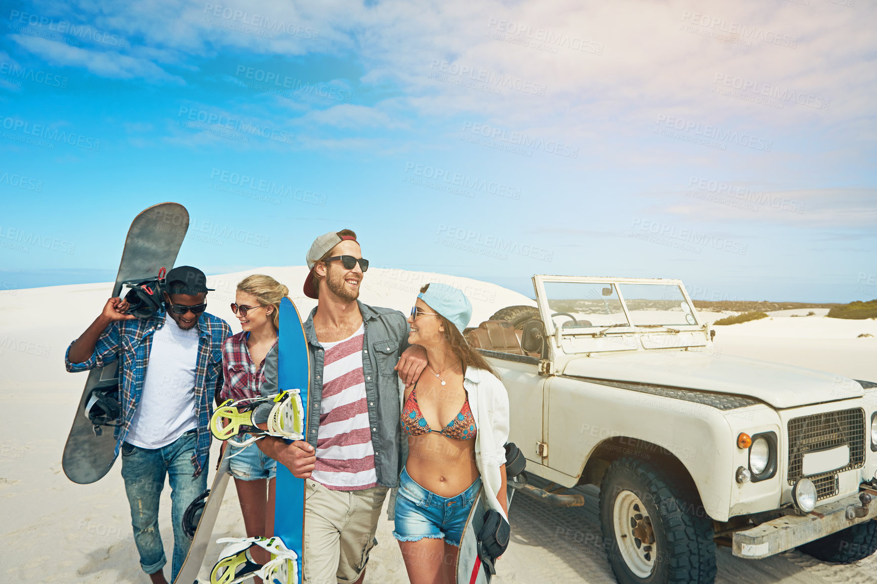 Buy stock photo Shot of a group of young friends going on a sand boarding road trip in the desert