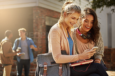 Buy stock photo Shot of friends sharing something on a cellphone on campus