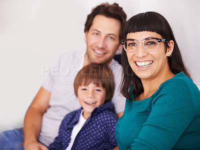 Buy stock photo Family, portrait and parents with kid on couch in living room, together with security and comfort for love. Bonding, care and happy people relax at home with smile on face, trust and support in life