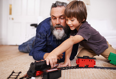 Buy stock photo Shot of a grandfather playing with toy trains with his grandson
