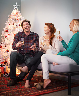 Buy stock photo Shot of three friends enjoying a glass of champagne at Christmas