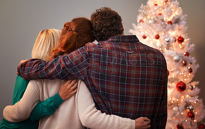 Buy stock photo Friends, embrace and Christmas tree for holiday vacation or festive season bonding, lights or gift giving. Man, woman and back in living room for winter break as relaxing celebration, family or love