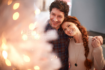 Buy stock photo Cropped shot of an affectionate couple standing by their Christmas tree