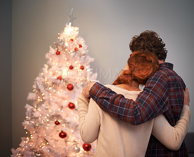 Buy stock photo Couple, hug and Christmas tree for holiday celebration in evening with light decoration, bonding or connection. Man, woman and back for winter vacation for gift giving or festive season, love or care