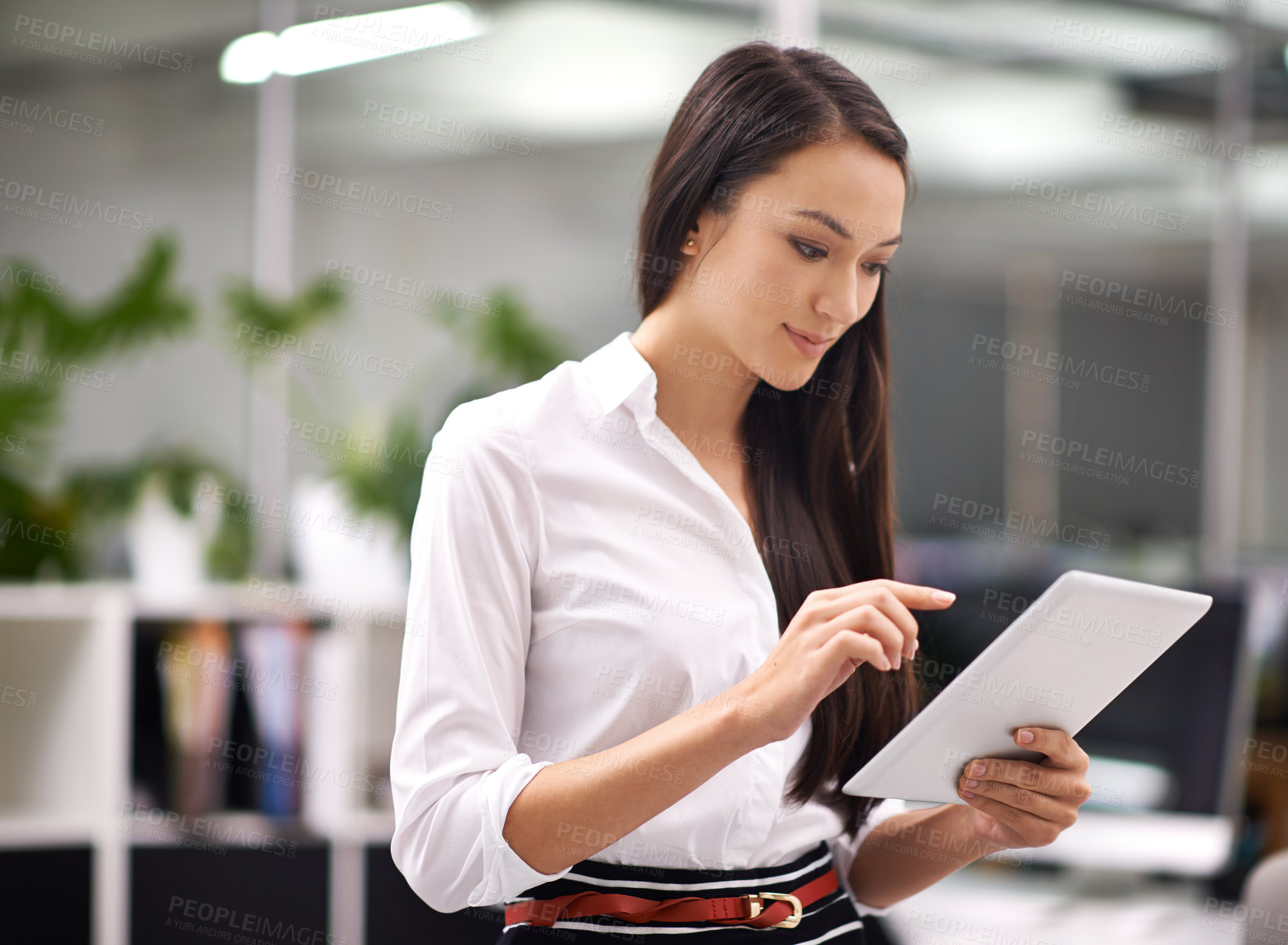 Buy stock photo Cropped shot of an attractive young woman using a digital tablet in the office