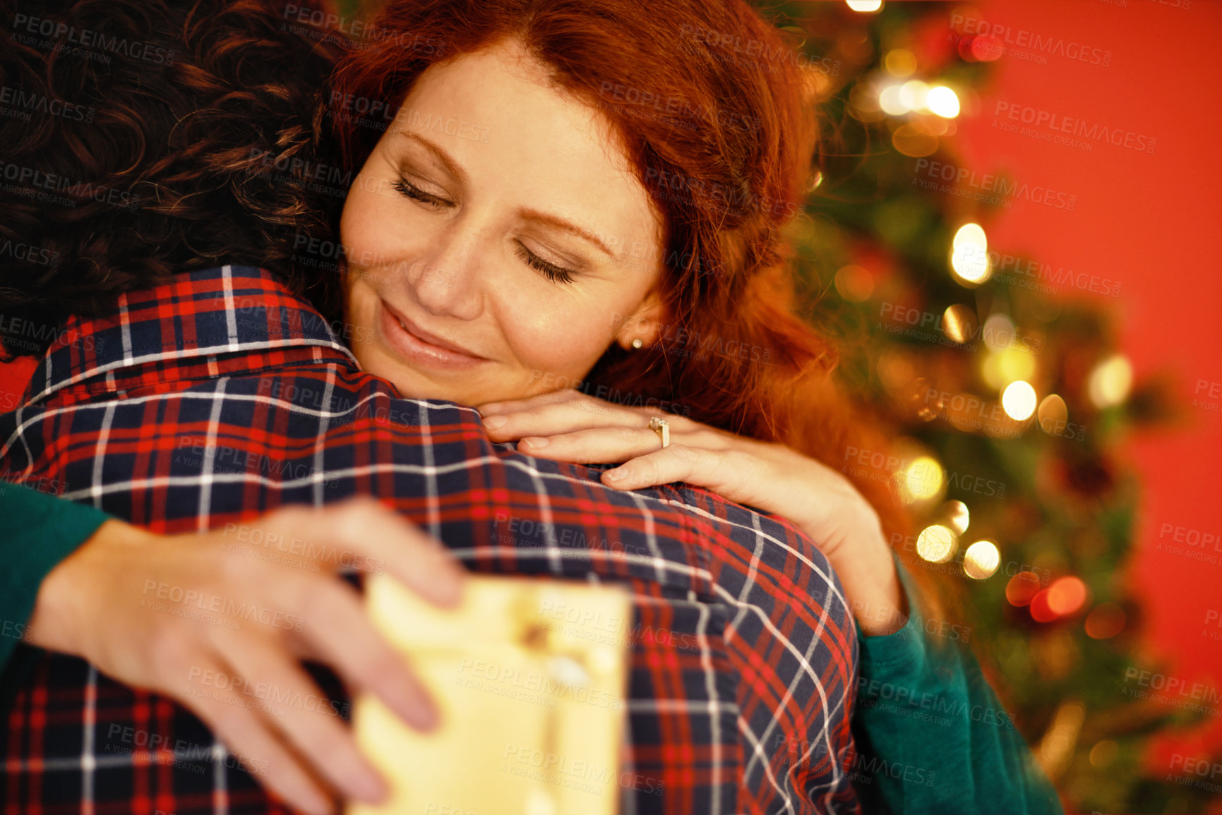 Buy stock photo Shot of a young woman embracing her boyfriend after receiving a gift from him