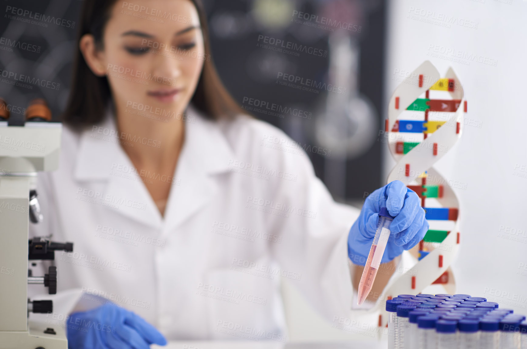 Buy stock photo Shot of a female scientist observing a sample in a test tube