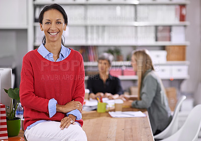Buy stock photo Portrait of a confident young businesswoman with her colleagues working in the background