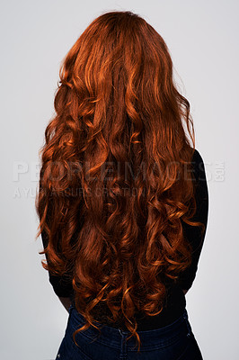 Buy stock photo Studio shot of a young woman with beautiful red hair posing against a gray background