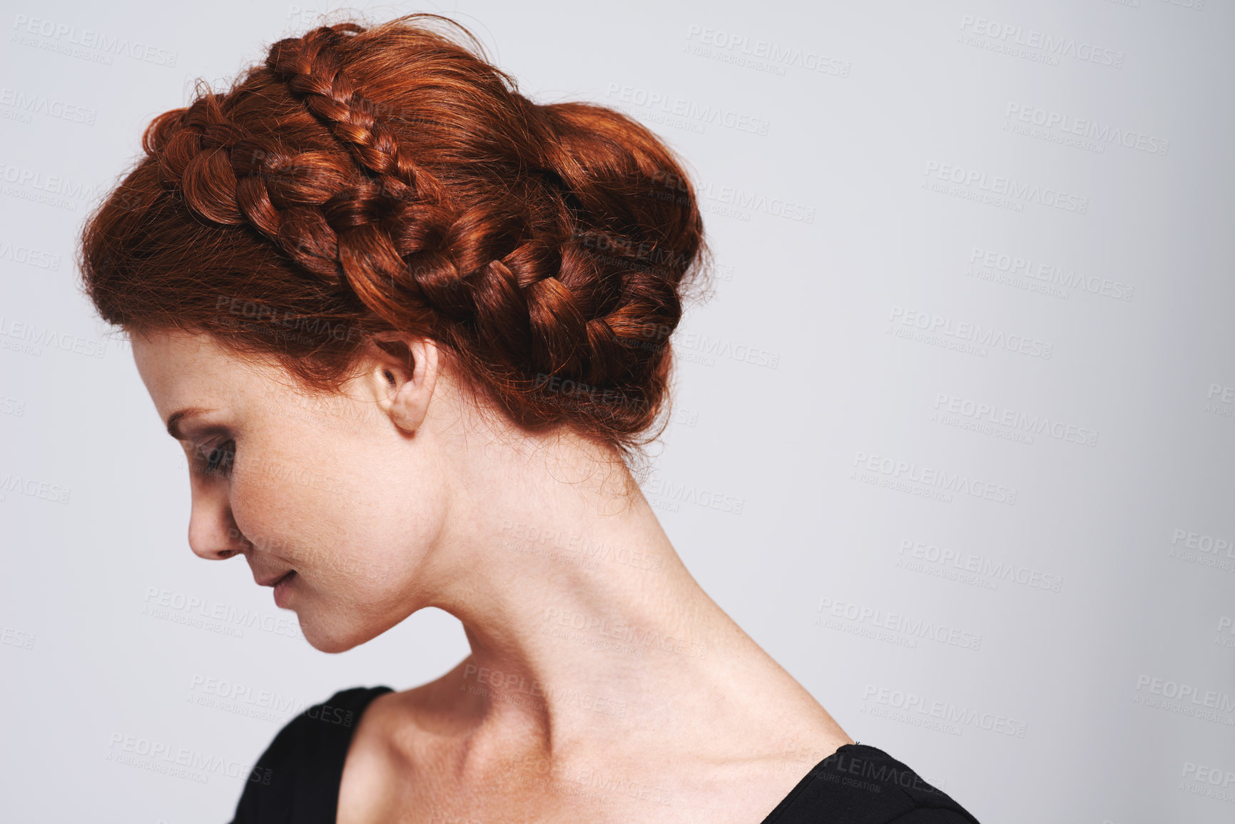 Buy stock photo Studio shot of a beautiful redhead woman with a braided up-do posing against a gray background