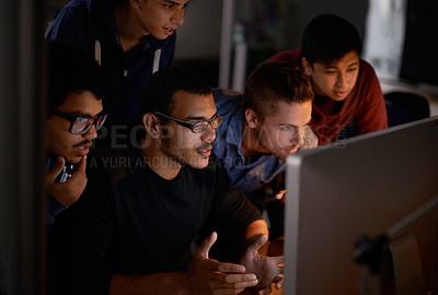 Buy stock photo Cropped shot of a group of young coworkers working in a dimly-lit office