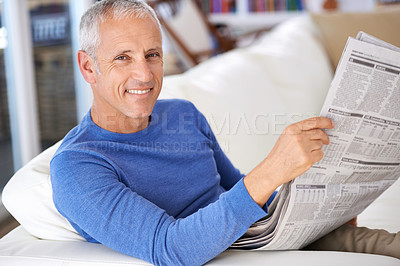 Buy stock photo Portrait of a happy mature man reading the newspaper