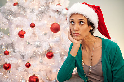 Buy stock photo Shot of a young woman looking displeased at Christmastime