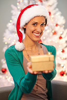 Buy stock photo Smile, santa hat and portrait of woman with gift at her home for christmas event, party or celebration. Happy, holidays and face of female person with festive xmas tree and present on sofa at house.