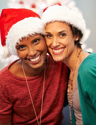 Buy stock photo A portrait of two happy best friends wearing santa hats at Christmastime