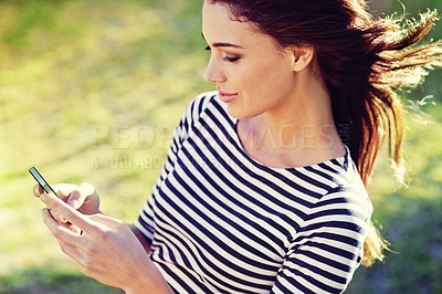 Buy stock photo Happy woman, cellphone and networking to relax in nature and typing a message for connection. Lady, smartphone and scroll for travel app to download and update on social media in England countryside