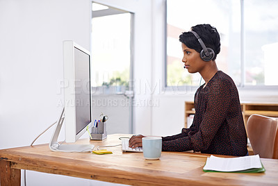 Buy stock photo A beautiful young woman wearing a headset while working on a computer in her office