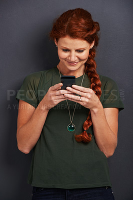 Buy stock photo Smile, reading and woman in studio with phone for social media, online chat or networking. Communication, internet and happy girl with smartphone, typing and scroll on mobile app with dark background