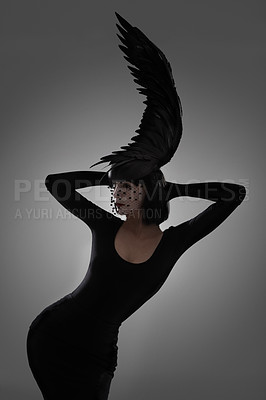 Buy stock photo Bird, fashion and art style woman in a studio with head piece, feather hat and abstract with unique creativity. Crow, silhouette and shadow with fantasy and with goth clothes and grey background