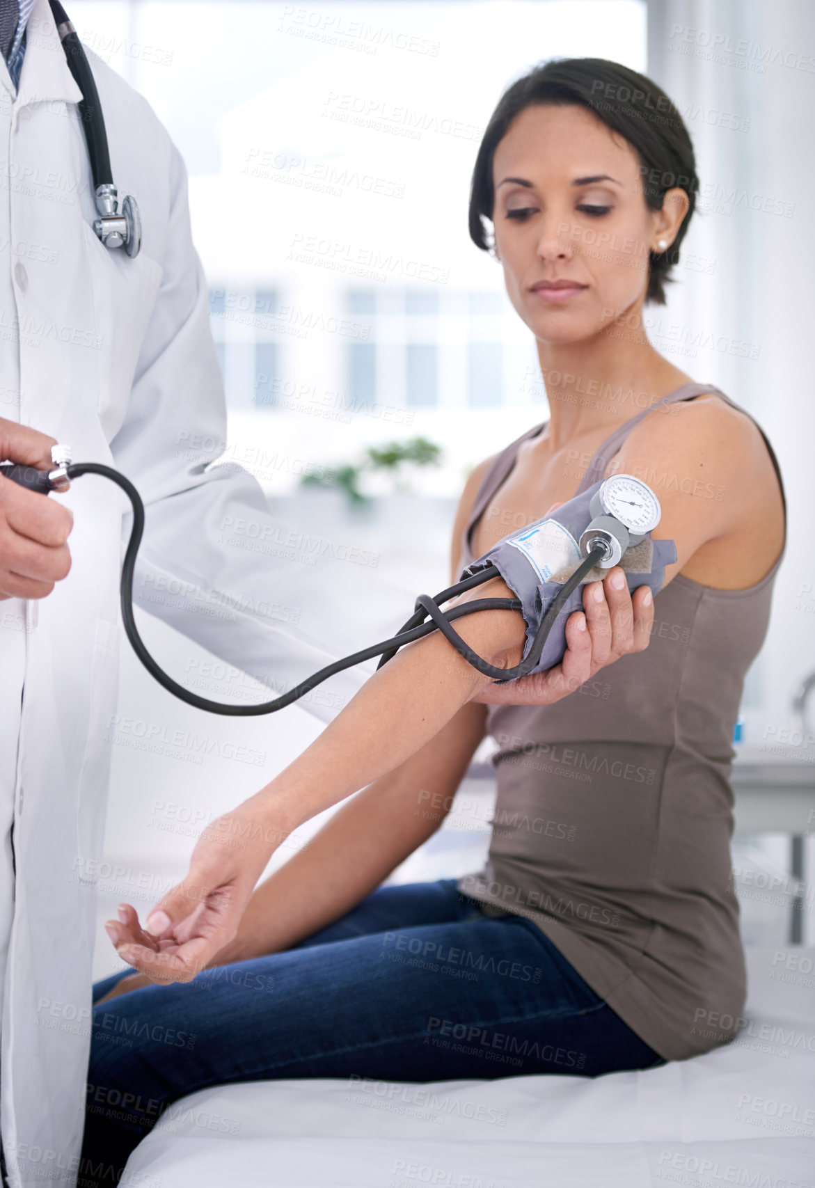 Buy stock photo Cropped shot of a doctor checking his patient's blood pressure