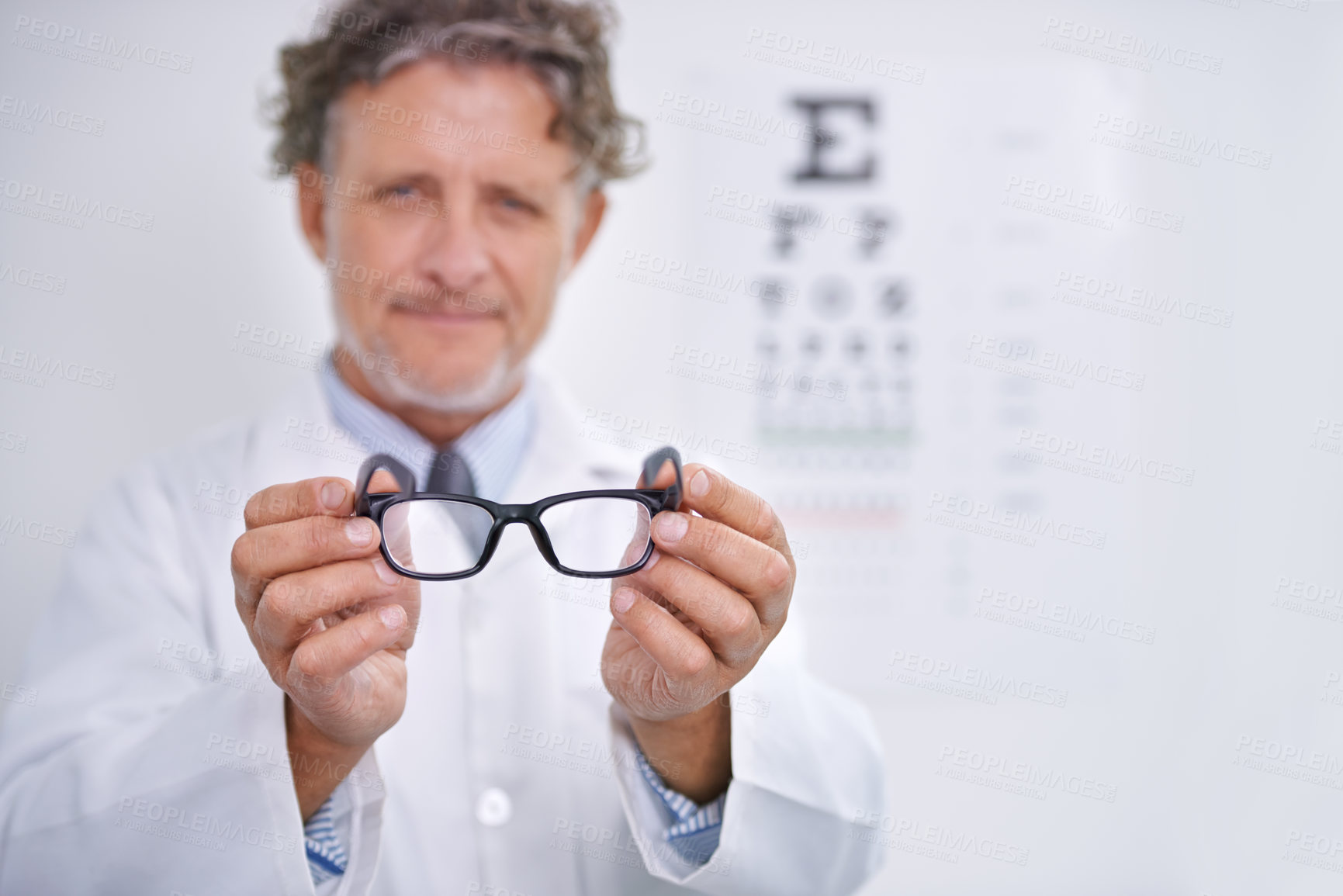 Buy stock photo Glasses, eye exam and portrait of optometrist in clinic to check or test vision in healthcare. Mature, doctor and reading letters on wall in medical assessment or consultation for contact lenses