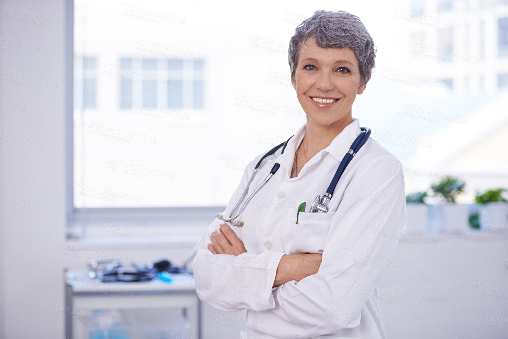 Buy stock photo Shot of a female doctor standing in a room with her arms crossed