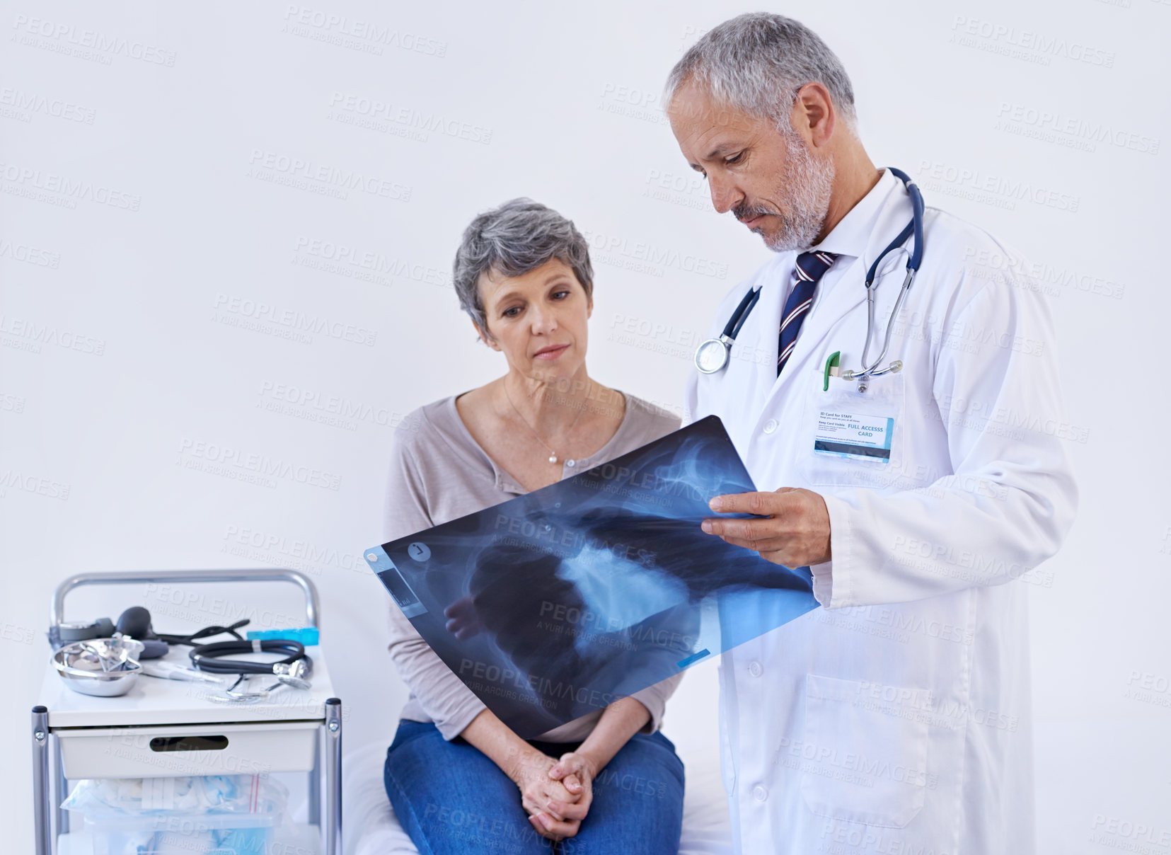 Buy stock photo Shot of a doctor explaining a x-ray to a patient