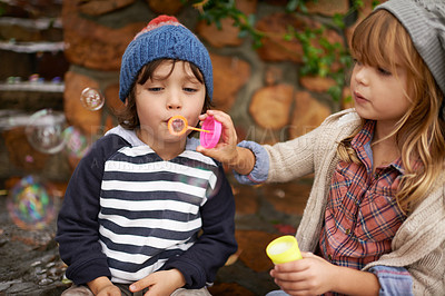 Buy stock photo Boy, girl and playing with bubbles, outdoors and garden in winter season. Bonding, love and sister with brother blowing for fun and entertainment, family and youth in nature with soap bubble 