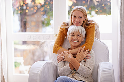 Buy stock photo Portrait of an attractive young woman sitting with her senior mother indoors