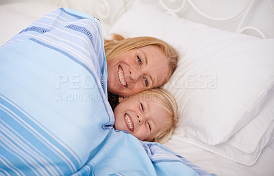 Buy stock photo Home, mom and girl with lying in bed together to smile for bonding, relax and chill on break. Parent, kid and happy in bedroom to cuddle with blanket for joy, fun and child development or growth.