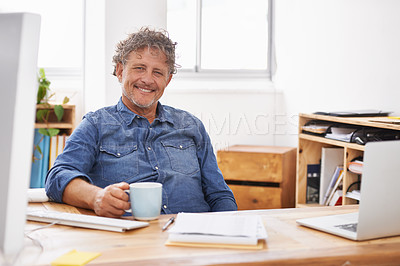Buy stock photo Portrait of a mature businessman having coffee while sitting at his desk