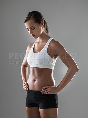 Buy stock photo Shot of an athletic woman standing with her hands on her hips during a workout session