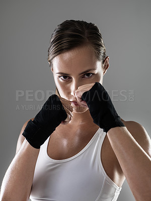 Buy stock photo Serious woman, portrait and boxer with fist ready for fight, workout or exercise in fitness on a gray studio background. Young female person or fighter in MMA challenge, competition or sport training
