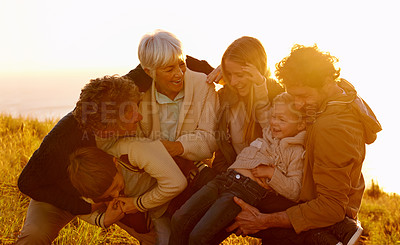 Buy stock photo A cropped shot of a family having fun on their sunset walk up a grassy hill