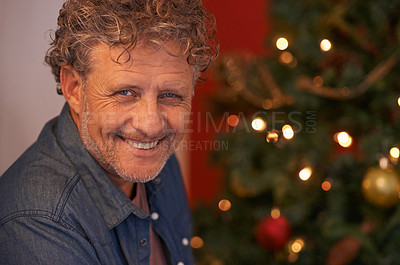 Buy stock photo Portrait of a mature man sitting beside a Christmas tree