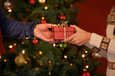 Buy stock photo Cropped shot of a couple exchanging a christmas gift
