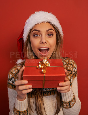 Buy stock photo Excited woman, portrait and Christmas with gift for festive season or December holiday on a red studio background. Happy female person, surprise or wow with hat for special present, prize or offer