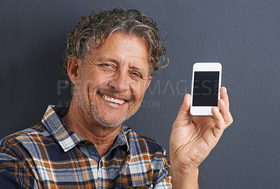 Buy stock photo Man, portrait and cellphone screen in studio for website communication, grey background or connectivity. Male person, face and smile with smartphone for online internet, advertising or mockup space
