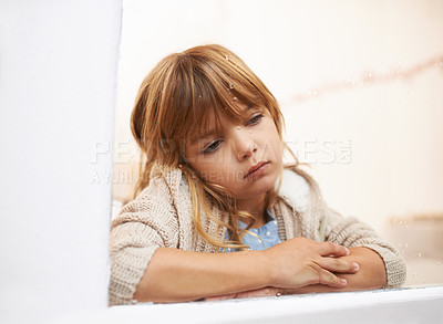Buy stock photo Window, sitting and child in house for bored, lonely or disappointed for rain or weather outdoor. Young girl or kid and sadness or sick in home for cold season and wait for play for childhood
