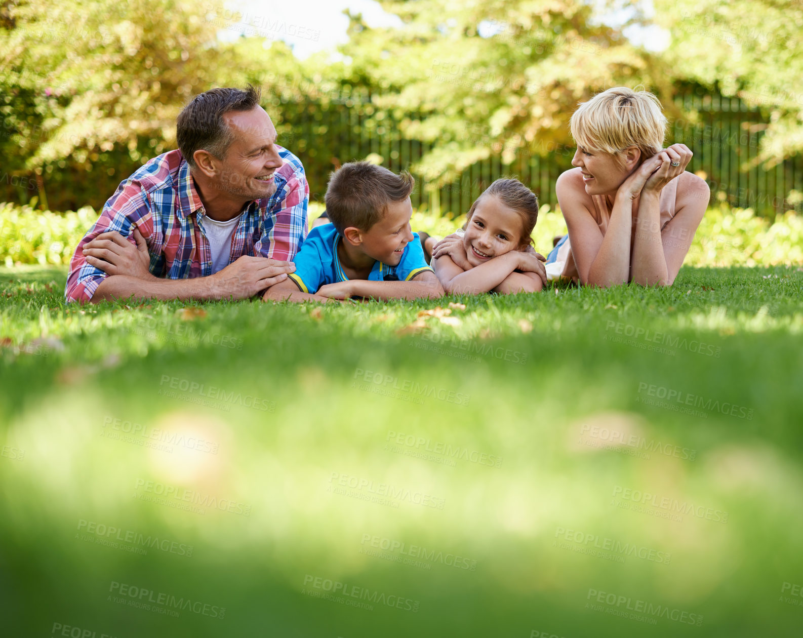 Buy stock photo Garden, park and happy family relax on grass in summer or parents and children together. Mother, father and kids smile in backyard on holiday or vacation in forest, woods or enjoy sunshine in nature