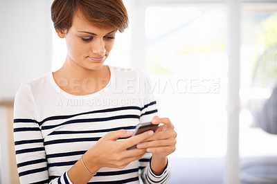 Buy stock photo Phone, smile and woman in living room networking on social media, mobile app or internet. Happy, technology and female person reading blog on website with cellphone in lounge at modern apartment.