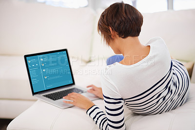Buy stock photo Rear view of a young woman working on her laptop while relaxing at home- ALL screen content is created from scratch by Yuri Arcurs' team of professionals for this particular photo shoot