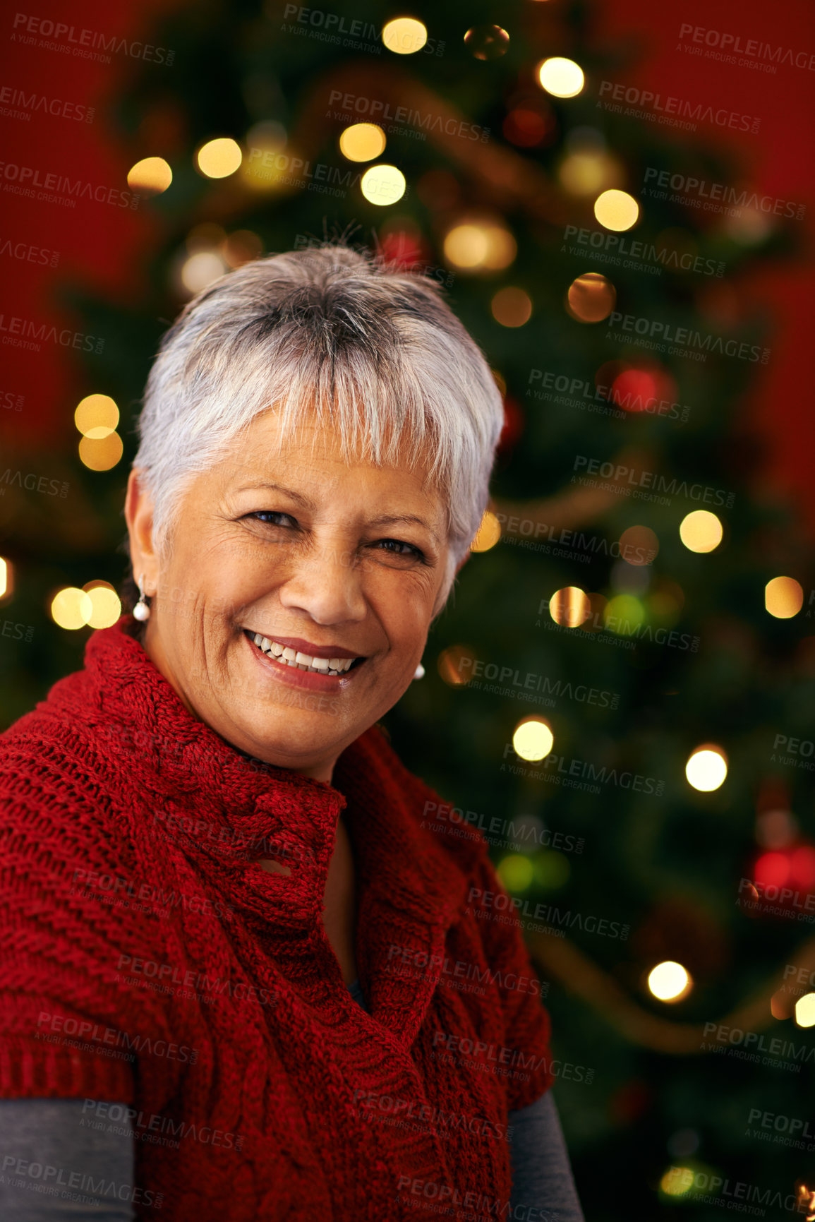 Buy stock photo Christmas, senior and portrait of happy woman in home for holiday celebration by tree with light bokeh. Xmas, face and smile of mature female person in house for festive season or party in Brazil